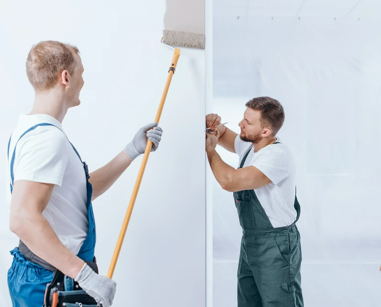 mężczyźni malują ścianę